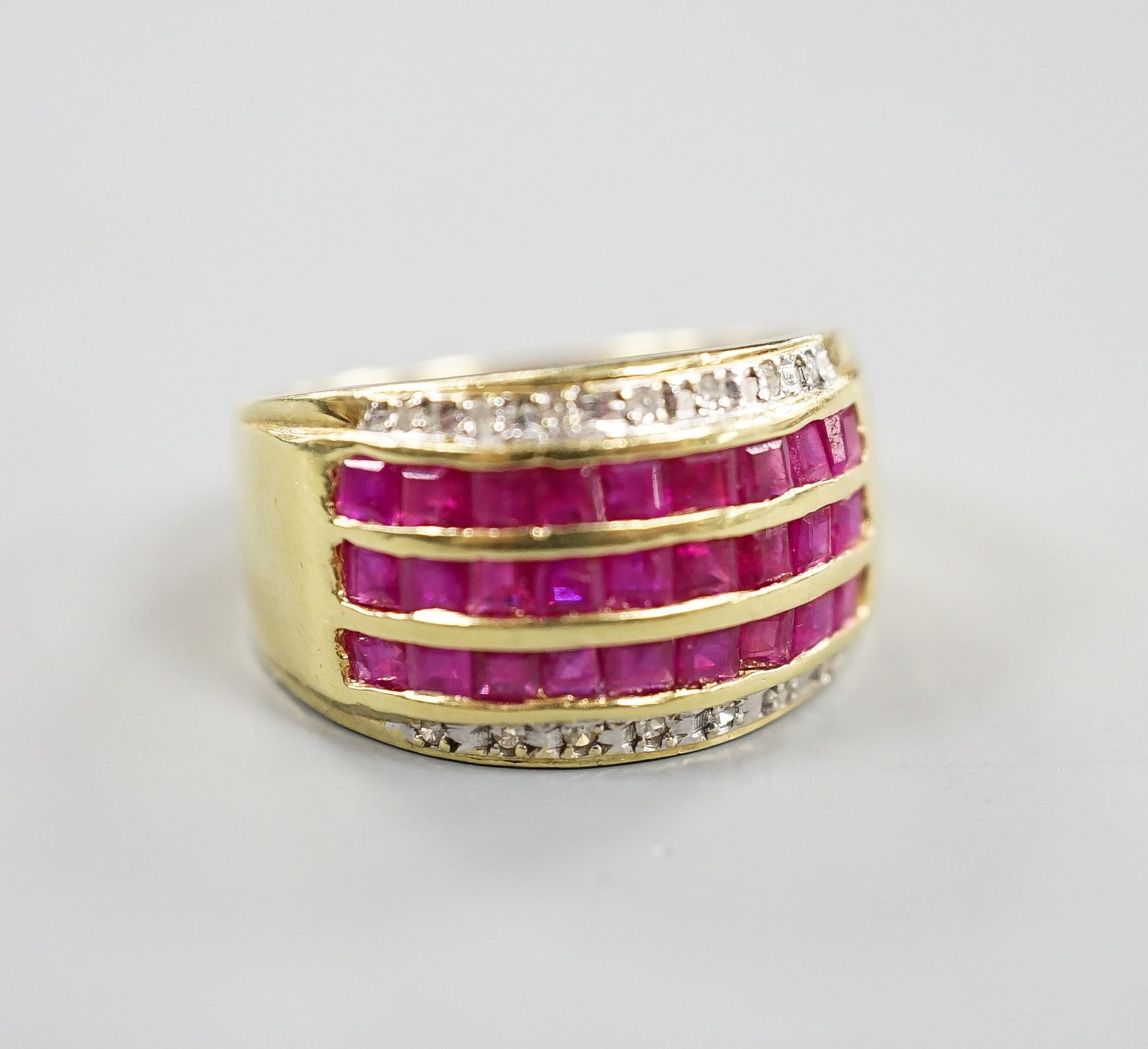 A modern 14k yellow metal, five row ruby and diamond set dress ring. size O, gross weight 4.9 grams.